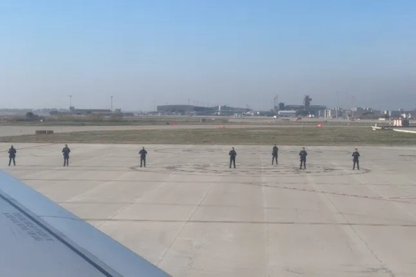 Поліцейські стоять на злітній смузі аеропорту Барселони, фотографія зроблена з точки зору пасажира на борту літака Turkish Airlines.