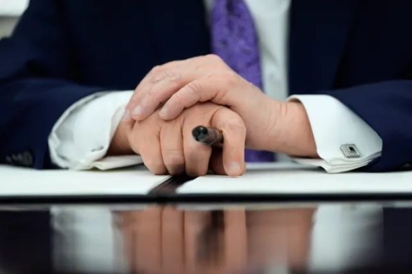 Президент Дональд Трамп тримає його за руки, виступаючи під час церемонії підписання в Овальному кабінеті Білого дому у четвер, 11 грудня 2025 року, у Вашингтоні. (Фото AP/Алекс Брендон)