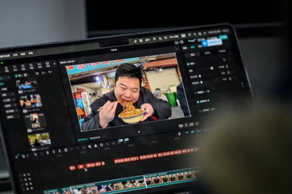 На фотографії, зробленій 15 грудня 2025 року, показано відео, на якому імітатор Дональда Трампа Раян Чень чекає на монтаж у своєму офісі в муніципалітеті Чунцін на південному заході Китаю. Простягнувши руки у фірмовій позі Дональда Трампа, імітатор Раян Чень так точно імітує голос і жестикуляцію президента США, що завдяки своїм кумедним відео він став феноменом соціальних мереж. (Фото Джейд Гао / AFP через Getty Images) / ДЛЯ ДОПОМОГИ: Китай-США-соціальна-комедія-Трамп, ПРОФІЛЬ Людовіка ЕРЕТА