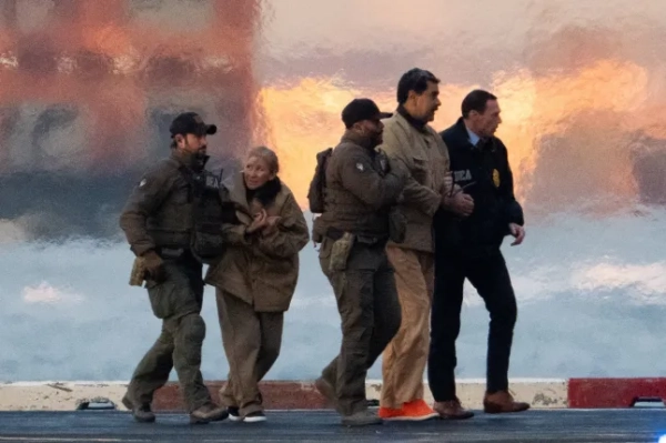 Правоохоронці виводять захопленого президента Венесуели Ніколаса Мадуро та його дружину Сілію Флорес з гелікоптера, коли Мадуро прямує до будівлі Мангеттенського суду США імені Даніеля Патріка для першої явки перед судом, де йому висунуть федеральні звинувачення у наркотероризмі, змові, незаконному обігові наркотиків, відмиванні грошей та інших злочинах, на вертолітному майданчику в центрі Мангеттена в Нью-Йорку, США, 5 січня 2026 року. REUTERS/Adam Gray