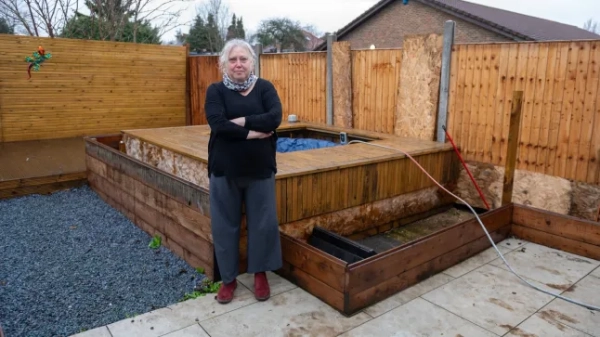 Роуз Сміт сперечається за землю зі своїм сусідом, Гіллінгдоном, 27 січня 2026 року. Роуз зображена поруч із гідромасажною ванною та парканом, який є центром суперечки. // Мрія бабусі на задньому дворі перетворилася на кошмар для сусідів: паркани зруйновані, тераса обпиляна, а гідромасажна ванна розхитана. Те, що мало бути щасливим новим розділом для 60-річної Роуз Сміт, перетворилося на садову війну після того, як сусід порубав її сад і заявив, що це його ???законне право???. Кошмар почався ще у квітні 2024 року, коли вчителька з Гейза, Західний Лондон, отримала шокуючого листа від Земельного реєстру. У ньому йшлося про те, що її сусід намагається претендувати на землю за її садом шляхом давності володіння, хоча Роуз була зареєстрованою власницею.