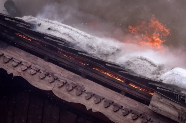 Полум'я охопило дах п'ятизіркового готелю Grandes Alpes на престижному французькому гірськолижному курорті Куршевель після пожежі, що спалахнула напередодні ввечері, 28 січня 2026 року, що змусило евакуювати 83 мешканців. Вранці 28 січня понад сто пожежників все ще працювали, щоб взяти під контроль сильну пожежу, походження якої залишається невідомим, і майже 300 людей було евакуйовано. (Фото Алекса МАРТІНА / AFP via Getty Images)