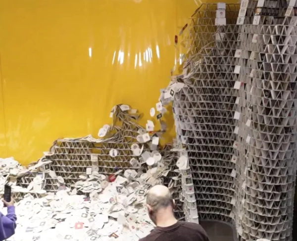 Історія з Jam Press (Вежа з пивних підставок). На фото: відеознімок, на якому видно момент, коли молода дівчина змушує вежу з пивних підставок Бенджаміна Клаппера драматично обвалитися. ВІДЕО: Момент, коли дівчина збиває вежу з пивних підставок, що потрапила до Книги рекордів Гіннеса, — зроблену з 63 000 підставок — на будівництво якої художник витратив МІСЯЦЬ. Молода дівчина зруйнувала гігантську вежу з пивних підставок, на будівництво якої художник витратив місяць. Вражаюча споруда, зроблена з 63 000 підставок для пива, була ретельно побудована Бенджаміном Клаппером. Він намагався встановити новий рекорд Гіннеса за допомогою вежі. Але його мрія зруйнувалася — разом з 60 000 пивних підставок. Однак 49-річний художник не звинувачував молоду дівчину. Вежа частково обвалилася під власною вагою безпосередньо перед завершенням будівництва, і гостей запросили пограти в «Пивний килимок Дженга» з рештою вежі. «Для мого проєкту «Всередині» я використав 63 000 підставок для пива», — розповів Бенджамін. Він розповів What's The Jam. «Його було подано до Книги рекордів Гіннеса як спробу встановити світовий рекорд. Я намагався побити існуючий рекорд у 70 000 пивних килимків та висоту 9,8 футів (3 м). На жаль, це не спрацювало, оскільки скульптура обвалилася під власною вагою за два дні до завершення, здавалося б, без будь-якої зовнішньої причини. Я працював над нею 28 днів, з 31 жовтня по 8 грудня минулого року. На завершення кожного рівня йшло близько чотирьох годин, і в середньому я будував один рівень на день. Отже, загалом я витратив близько 120 годин на будівництво скульптури». Бенджамін, родом з міста Пульгайм у Німеччині, побудував вежу в торговому центрі Rhein-Center у сусідньому Кельні. Самозайнятий медіаінженер сказав, що залишки скульптури були знесені 10 січня, і відео стало вірусним. Він пояснив: «Того дня я запросив своїх помічників по проекту пограти в «Пивний килимок Дженга». «Кожна людина по черзі знімала пивний килимок з конструкції, доки той не впав. Переможницею стала дочка одного з моїх помічників. «Вона з першої спроби збила «Inside», витягнувши той, що лежав горизонтально. Прямі трансляції, відео та фотографії будівництва та знесення зібрали мільйони переглядів у соціальних мережах». Він додав: «Реакції варіювалися від «Це ж ШІ!?» до «Як шкода, що не спрацювало?». Бенджамін, який керує медіакомпанією MuVi 3D GmbH, сказав, що почав будувати скульптури пивних підставок ще дитиною. «Поступово конструкції ставали все більшими й більшими», – пояснив він. «Я завершив свій перший великий проект 33 роки тому. Відтоді я будую великі скульптури пивних підставок кожні кілька років. І вони завжди створюються у громадських місцях. Це також моя головна мотивація для створення цих скульптур: глядачам не лише представляють готовий витвір мистецтва, вони також можуть спостерігати за процесом створення. «Серед виставкових майданчиків були кінотеатр-кінотеатр, художня галерея, дитячий садок та багато іншого. Моєю найвищою спорудою було «Місто колон» у 2002 році. «Найвища з 21 колони досягла висоти 10,2 фута (3,10 м)». Він додав: «Одного разу до мене підійшов восьмирічний хлопчик і попросив автограф. Звісно, я написав його для нього на пивному килимку!» КІНЕЦЬ ПРИМІТКИ РЕДАКТОРА: Ліцензія на використання відео: (НЕВИКЛЮЧНА) Ми отримали невиключну ліцензію від власника авторських прав. Копія ліцензії доступна за запитом. Обмеження відео: немає.