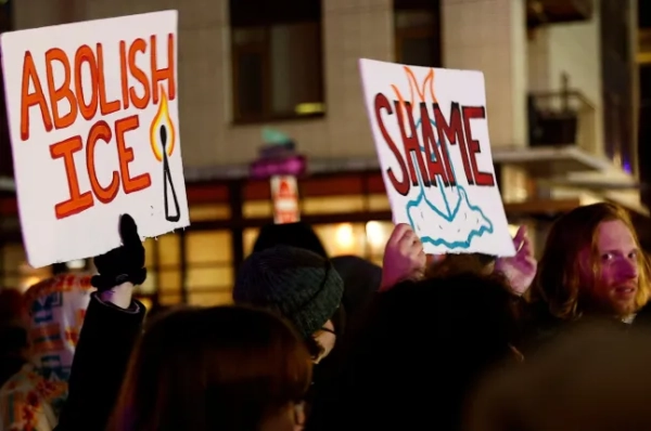 Протестувальники тримають плакати з написами «Скасувати ICE» та «Ганьба» після того, як агенти ICE застрелили чоловіка та жінку в Портленді.