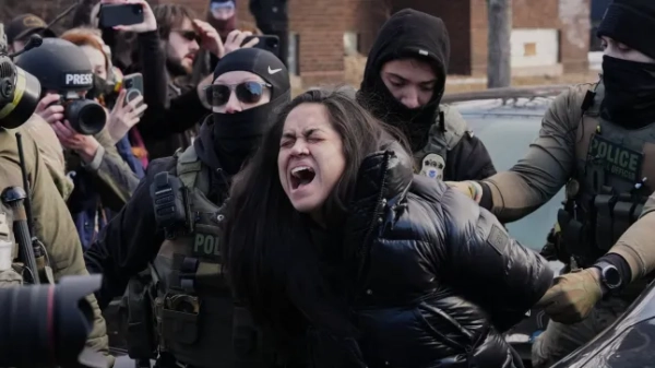 Федеральні агенти затримали особу поблизу місця події, де Рене Гуд була смертельно поранена офіцером ICE минулого тижня, у вівторок, 13 січня 2026 року, у Міннеаполісі. (Фото AP/Адам Грей)