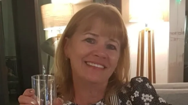 Олена Волш посміхається, тримаючи напій.