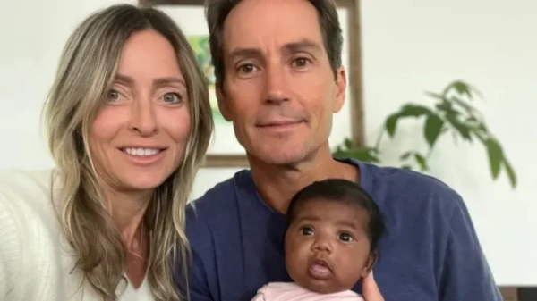 Стівен Міллс та Тіффані Скор тримають немовля.