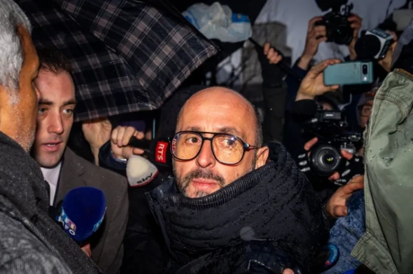 Співвласник бару Le Constellation Жак Моретті (у центрі) прибуває на слухання до прокуратури кантону Вале в Сьоні 12 лютого 2026 року. 41 людина, більшість з яких підлітки, загинула, а 115 отримали поранення внаслідок пожежі, яка охопила бар Le Constellation на гірськолижному курорті Кран-Монтана в новорічну ніч. (Фото Максима ШМІДА / AFP via Getty Images)