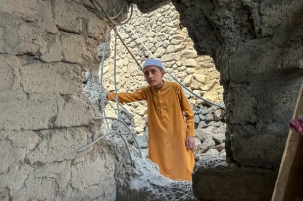 Хлопчик оглядає пошкоджений будинок після нічних прикордонних боїв між Пакистаном та Афганістаном у Баджаурі, провінція Хайбер-Пахтунхва, 27 лютого 2026 року. Пакистан бомбардував великі міста Афганістану, включаючи столицю Кабул, 27 лютого, а міністр оборони Ісламабаду оголосив сусідів у стані «відкритої війни» після місяців взаємних зіткнень. (Фото Фазала РАХМАНА / AFP via Getty Images)