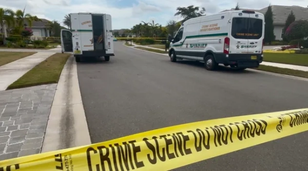 Жовта стрічка, що огортає місце злочину вздовж житлової дороги в США