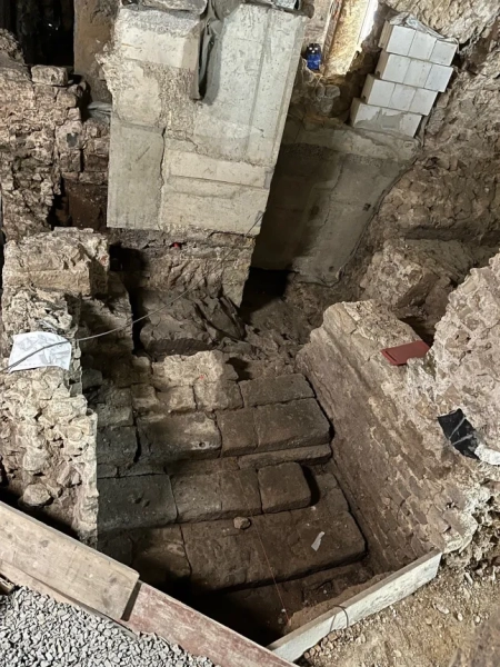 МАРК ВОРГАН Археологи, які працюють під історичним центром Кельна, виявили надзвичайно добре збережені римські залишки, зокрема рідкісну святиню домашніх богів, знайдену вперше в Північній Європі. За словами міських чиновників, знахідку було зроблено під час розкопок, пов'язаних з новим підземним маршрутом для відвідувачів у Єврейському музеї MiQua ??? LVR в Археологічному кварталі Кельна. Найбільш вражаючим відкриттям є ларарій – домашнє святилище, присвячене ларам, божествам-захисникам дому, – знайдене в колишньому римському преторії, палаці губернатора, який колись символізував імператорську владу в провінції Нижня Германія. Ларії були широко поширені в римських будинках по всьому Середземномор'ю. Цей, що датується II століттям, є унікальним на північ від Альп, а аналогічні приклади раніше знаходили лише в римських містах, похованих внаслідок вивержень вулканів, таких як Помпеї. Команда дослідників, яка брала участь у розкопках, каже, що кельнська знахідка майже безпрецедентна: сліди оригінального настінного розпису досі видно всередині вівтарної ніші. Невеликі отвори від цвяхів над і поруч із нішею свідчать про те, що колись святиню прикрашали гірлянди. Під ним чітка лінія розриву позначає місце, де спочатку був встановлений вівтарний стіл. Цю кам'яну плиту також було виявлено під час розкопок, і очікується, що її буде відновлено у початковому положенні. Відкриття були зроблені під час робіт, що проводилися містом Кельн у рамках підготовки до підземної екскурсії музею. Оскільки ділянки нового маршруту опускаються на незвичайну глибину, археологи змогли ідентифікувати споруди, які зазвичай втрачаються, будучи зруйнованими пізнішими будівельними роботами. У цьому випадку останки збереглися, оскільки вони вже були поховані в римські часи. Їхнє розташування на та під колишнім схилом річки Рейн означало, що вони були запечатані валами на початку античності, захищаючи їх від пізніших пошкоджень. Серед інших значущих знахідок - фундамент апсиди, що належить до великої багатонефної римської базиліки, що датується IV століттям. Її товщина досягала чотирьох метрів, і спочатку вважалося, що вона була зроблена з римського литого бетону, відомого як opus caementicium. Детальне дослідження виявило замість цього шарувату конструкцію з туфу, базальту та вапняку, скріплену надзвичайно міцним розчином з цегли та гравію. До розкопок споруда виглядала на площі ратуші Кельна лише як невелике заглиблення. Зараз вона вперше доступна для відвідувачів. Археологи також виявили сходи кінця I століття, які були виявлені лише під час поточних робіт. Сходи колись з'єднували низовину поблизу Рейну з вищою місцевістю, пов'язаною з раннім преторієм. Точна точка, де закінчувалися сходи, залишається невідомою. Сходи рідко зберігаються в археології Кельна, оскільки більшість римських будівель збереглися лише на рівні фундаменту. Фахівці кажуть, що цей екземпляр зберігся завдяки сприятливим топографічним умовам, коли ранні римські споруди були поховані під час засипання ще в римський період. Очікується, що знахідки стануть центральною частиною підземної екскурсії, коли музей MiQua відкриється для публіки. У ньому представлено: Фрагмент римських сходів I століття. Де: Кельн, Німеччина Коли: 24 лютого 2026 р. Авторство: Місто Кельн/Римсько-германський музей, Франциска Барц/Зображення обкладинки **З усіх питань використання та запитів звертайтеся за адресою info@cover-images.com - +44 (0)20 3397 3000 ЛИШЕ ДЛЯ РЕДАКЦІЙНОГО ВИКОРИСТАННЯ. МАТЕРІАЛИ ДЛЯ ВИКОРИСТАННЯ ЛИШЕ РАЗОМ З РЕДАКЦІЙНОЮ СТАТТЮ. ВИКОРИСТАННЯ ЦИХ МАТЕРІАЛІВ ДЛЯ РЕКЛАМИ, МАРКЕТИНГУ АБО БУДЬ-ЯКИХ ІНШИХ КОМЕРЦІЙНИХ ЦІЛЕЙ СУВОРО ЗАБОРОНЕНО. АВТОРСЬКЕ ПРАВО НА МАТЕРІАЛИ ЗАЛИШАЄТЬСЯ У ЗАЯВЛЕНОГО ПОСТАЧАЛЬНИКА.**