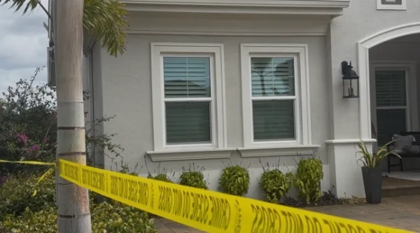 Жовта стрічка для позначення місця злочину вздовж житлового будинку