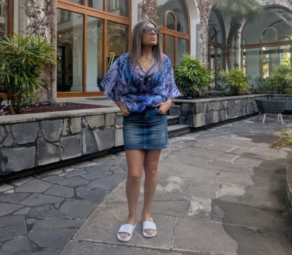 Жінка у внутрішньому дворі готелю, заповненому рослинами