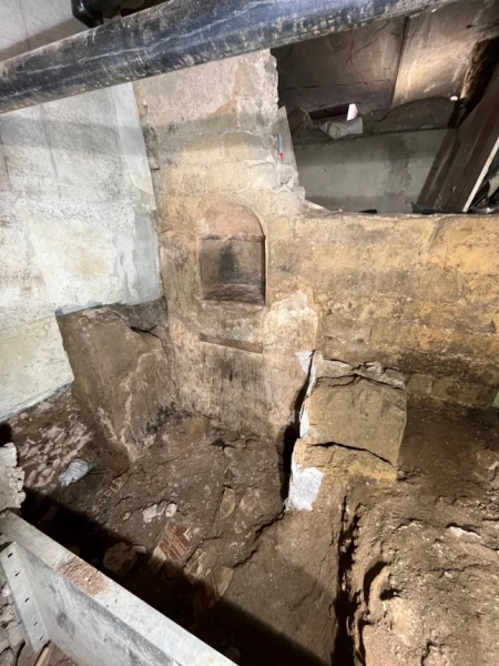 МАРК ВОРГАН Археологи, які працюють під історичним центром Кельна, виявили надзвичайно добре збережені римські залишки, зокрема рідкісну святиню домашніх богів, знайдену вперше в Північній Європі. За словами міських чиновників, знахідку було зроблено під час розкопок, пов'язаних з новим підземним маршрутом для відвідувачів у Єврейському музеї MiQua ??? LVR в Археологічному кварталі Кельна. Найбільш вражаючим відкриттям є ларарій – домашнє святилище, присвячене ларам, божествам-захисникам дому, – знайдене в колишньому римському преторії, палаці губернатора, який колись символізував імператорську владу в провінції Нижня Германія. Ларії були широко поширені в римських будинках по всьому Середземномор'ю. Цей, що датується II століттям, є унікальним на північ від Альп, а аналогічні приклади раніше знаходили лише в римських містах, похованих внаслідок вивержень вулканів, таких як Помпеї. Команда дослідників, яка брала участь у розкопках, каже, що кельнська знахідка майже безпрецедентна: сліди оригінального настінного розпису досі видно всередині вівтарної ніші. Невеликі отвори від цвяхів над і поруч із нішею свідчать про те, що колись святиню прикрашали гірлянди. Під ним чітка лінія розриву позначає місце, де спочатку був встановлений вівтарний стіл. Цю кам'яну плиту також було виявлено під час розкопок, і очікується, що її буде відновлено у початковому положенні. Відкриття були зроблені під час робіт, що проводилися містом Кельн у рамках підготовки до підземної екскурсії музею. Оскільки ділянки нового маршруту опускаються на незвичайну глибину, археологи змогли ідентифікувати споруди, які зазвичай втрачаються, будучи зруйнованими пізнішими будівельними роботами. У цьому випадку останки збереглися, оскільки вони вже були поховані в римські часи. Їхнє розташування на та під колишнім схилом річки Рейн означало, що вони були запечатані валами на початку античності, захищаючи їх від пізніших пошкоджень. Серед інших значущих знахідок - фундамент апсиди, що належить до великої багатонефної римської базиліки, що датується IV століттям. Її товщина досягала чотирьох метрів, і спочатку вважалося, що вона була зроблена з римського литого бетону, відомого як opus caementicium. Детальне дослідження виявило замість цього шарувату конструкцію з туфу, базальту та вапняку, скріплену надзвичайно міцним розчином з цегли та гравію. До розкопок споруда виглядала на площі ратуші Кельна лише як невелике заглиблення. Зараз вона вперше доступна для відвідувачів. Археологи також виявили сходи кінця I століття, які були виявлені лише під час поточних робіт. Сходи колись з'єднували низовину поблизу Рейну з вищою місцевістю, пов'язаною з раннім преторієм. Точна точка, де закінчувалися сходи, залишається невідомою. Сходи рідко зберігаються в археологічних даних Кельна, оскільки більшість римських будівель збереглися лише на рівні фундаменту. Фахівці кажуть, що цей екземпляр зберігся завдяки сприятливим топографічним умовам, коли ранні римські споруди були поховані шляхом засипання ще в римський період. Очікується, що знахідки стануть центральною частиною підземної екскурсії, коли музей MiQua відкриється для публіки. У ньому представлені: Огляд лараріуму із залишками бічних рам. Де: Кельн, Німеччина Коли: 24 лютого 2026 р. Авторство: Місто Кельн/Римсько-германський музей, Міхаель Віен/Зображення обкладинки **З усіх питань використання та запитів звертайтеся за адресою info@cover-images.com - +44 (0)20 3397 3000 ЛИШЕ ДЛЯ РЕДАКЦІЙНОГО ВИКОРИСТАННЯ. МАТЕРІАЛИ ДЛЯ ВИКОРИСТАННЯ ЛИШЕ РАЗОМ З РЕДАКЦІЙНОЮ СТАТТЮ. ВИКОРИСТАННЯ ЦИХ МАТЕРІАЛІВ ДЛЯ РЕКЛАМИ, МАРКЕТИНГУ АБО БУДЬ-ЯКИХ ІНШИХ КОМЕРЦІЙНИХ ЦІЛЕЙ СУВОРО ЗАБОРОНЕНО. АВТОРСЬКЕ ПРАВО НА МАТЕРІАЛИ ЗАЛИШАЄТЬСЯ У ЗАЯВЛЕНОГО ПОСТАЧАЛЬНИКА.**