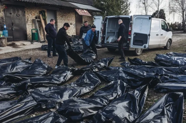 БУЧА, УКРАЇНА – 7 КВІТНЯ: (ПРИМІТКА РЕДАКТОРА: На зображенні зображено смерть) Волонтери переносять тіла мирних жителів на кладовищі в Бучі, Україна, 7 квітня 2022 року. (Фото Дієго Еррери Карседо/Anadolu Agency через Getty Images)