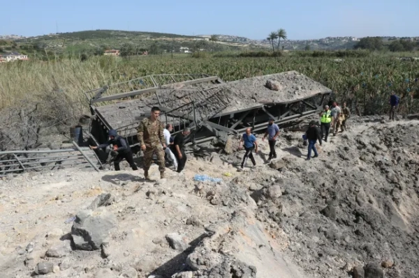 Люди перетинають пішки міст Касмія, останній міст між південними ліванськими містами регіонів Тир і Сидон, після того, як 16 квітня 2026 року він став мішенню ізраїльського авіаудару. 16 квітня ізраїльські військові завдали двох ударів по ключовому мосту на півдні Лівану, зруйнувавши його, повідомило державне Національне інформаційне агентство (NNA). «Ворожа авіація завдала двох послідовних ударів по мосту Касмія, останньому мосту між регіонами Тир і Сидон, повністю його зруйнувавши», – йдеться в повідомленні NNA. (Фото Кавната ХАДЖУ / AFP via Getty Images)