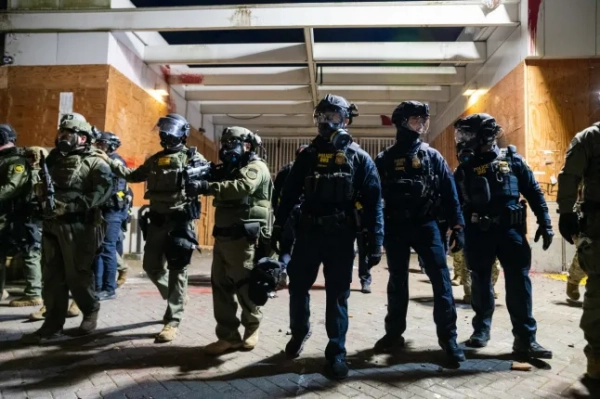 Обов'язкове джерело: Фото Бенджаміна Хансона/ZUMA Press Wire/Shutterstock (16807474ah) Співробітники Прикордонної служби США та Міністерства внутрішньої безпеки тримають лінію проти протестувальників під час протесту проти ICE біля будівлі Імміграційної та митної служби в суботу, 28 березня 2026 року в Портленді, штат Орегон. No Kings 3 Portland ICE Facility, Орегон, США - 28 березня 2026 року