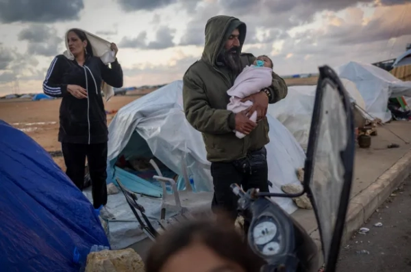 38-річний Ахмад Аль-Сагір тримає свого двомісячного сина Адама Аль-Сагіра біля сімейного намету у тимчасовому таборі для переміщених осіб на тлі ескалації воєнних дій між Ізраїлем та Хезболлою, на тлі продовження конфлікту між США та Ізраїлем з Іраном у Бейруті, Ліван, 30 березня 2026 року. REUTERS/Adnan Abidi