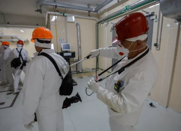 epa12911000 Інспектор з радіаційного контролю перевіряє відвідувачів після їхнього візиту під новим безпечним конфайнментом, що охоплює 4-й блок Чорнобильської атомної електростанції, у Чорнобилі, Україна, 23 квітня 2026 року (опубліковано 24 квітня 2026 року). 26 квітня 2026 року Україна відзначатиме 40-ту річницю Чорнобильської катастрофи. Вибух реактора №4 Чорнобильської атомної електростанції рано вранці 26 квітня 1986 року досі вважається найгіршою ядерною катастрофою на сьогоднішній день. EPA/СЕРГІЙ ДОЛЖЕНКО