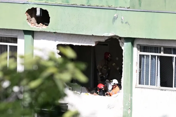 Пожежники оглядають місце падіння уламків невеликого літака, який врізався в будівлю в центрі міста Белу-Орізонті, штат Мінас-Жерайс, Бразилія, 4 травня 2026 року. Невеликий літак врізався в стіну будівлі в південно-східному місті Белу-Орізонті 4 травня, внаслідок чого загинули пілот і другий пілот, повідомили пожежники. (Фото GLEDSTON TAVARES / AFP via Getty Images)
