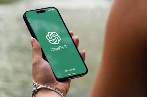 Дівчина в парку тримає смартфон iPhone 14 Pro з чат-ботом ChatGPT зі штучним інтелектом на екрані. Озеро на задньому плані. Ріо-де-Жанейро, Бразилія. Травень 2023.; Shutterstock ID 2303792963; замовлення_на_продаж: -; завдання: -; клієнт: -; інше: