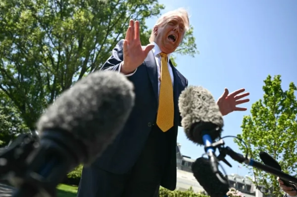 ТОП-КАДЕР - Президент США Дональд Трамп звертається до преси перед тим, як піти на посадку на борт Marine One, відпливаючи з Південної галявини Білого дому у Вашингтоні, округ Колумбія, 12 травня 2026 року. Президент Трамп заявив у понеділок, що готовий обговорити продаж американської зброї Тайваню під час свого візиту цього тижня до Пекіна, оскільки він припустив, що його особиста взаємодія з колегою Сі Цзіньпіном запобіжить китайському вторгненню на острів. Трамп візьме з собою високопосадовців США для поїздки, яка, як очікується, буде значною мірою зосереджена на сподіваннях президента США щодо активізації торгівлі. (Фото Кента НІШІМУРИ / AFP via Getty Images)