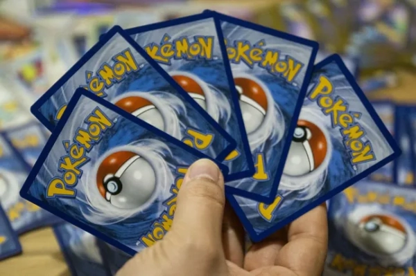 На цій фотографії зображено колекційні картки з гри Pokemon Trading Card Game (TCG) у квартирі колекціонера-аматора в Парижі 11 березня 2026 року. Картки покемонів із зображенням «маленьких монстрів», які приваблюють як дітей, так і дорослих суперфанатів, за останні роки різко зросли в ціні. Колекціонування карток покемонів стало формою інвестицій, що виходить за рамки колекціонування, обміну чи гри. (Фото Мартіна ЛЕЛЬЄВРА / AFP via Getty Images)