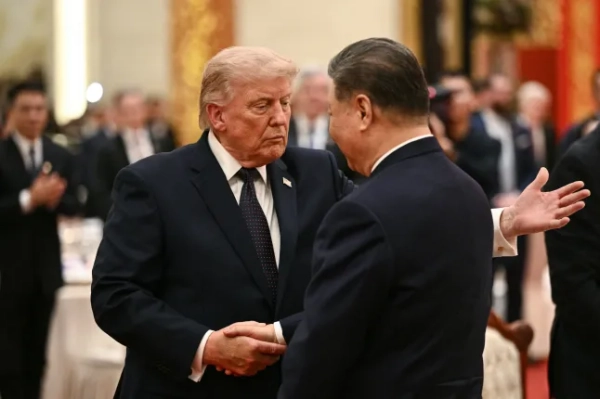 ТОП-КАДР - Президент Китаю Сі Цзіньпін (праворуч) та президент США Дональд Трамп потискають один одному руки під час державного бенкету у Великому залі народних зборів у Пекіні 14 травня 2026 року. (Фото Брендана СМІАЛОВСЬКОГО / AFP via Getty Images)