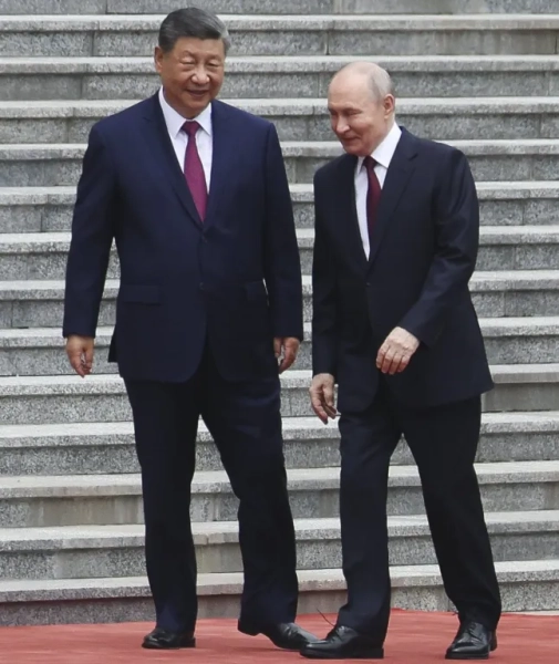 Президент Росії Володимир Путін гуляє з головою Китаю Сі Цзіньпіном під час церемонії привітання у Домі народних зборів 20 травня 2026 року в Пекіні, Китай.