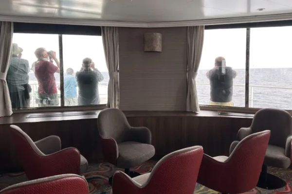 Пасажири круїзного лайнера MV Hondius, ураженого хантавірусом, оглядають горизонт у бінокль під час своєї подорожі до іспанського порту Тенерифе, 6 травня 2026 року. (Фото AP) 15804795
