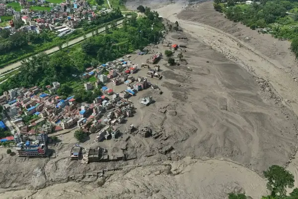 Пошкоджені будинки стоять на хисткому ґрунті поблизу розлитих, завалених уламками берегів річки Трішулі після раптових повеней у районі Нувакот, Непал, у середу, 26 серпня 2026 року. (AP Photo/Niranjan Shrestha)