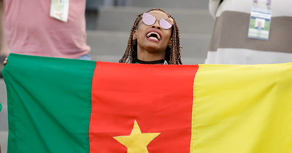 Cameroon fan holds a flag prior to the Confederations Cup, Group B soccer match between Germany and Cameroon