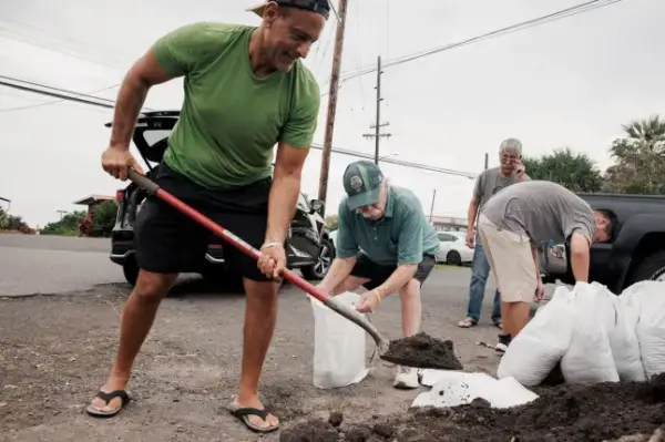 Shaheer Faltas, left, and his father-in-law, Joe Brosnan, fill sandbags in preparation for the arrival of Tropical Storm Lala in Captain Cook, Hawaii, Friday, Aug. 14, 2026. (Stephen Lam/San Francisco Chronicle via AP)