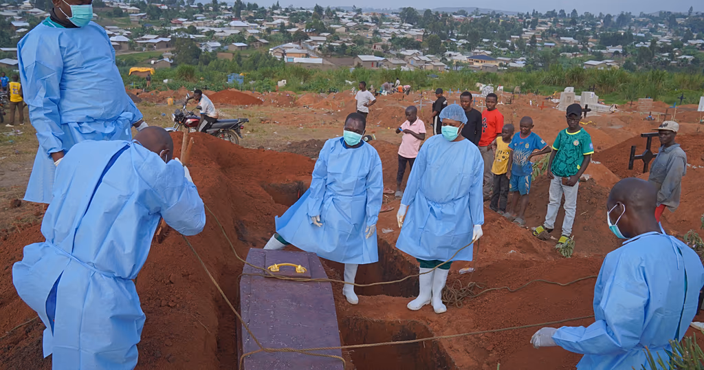 People dressed in protective gear unload a coffin containing the remains of six-year-old Baudjo Baraka Jules, who died of Ebola, in Bunia, DRC, Aug. 18, 2026