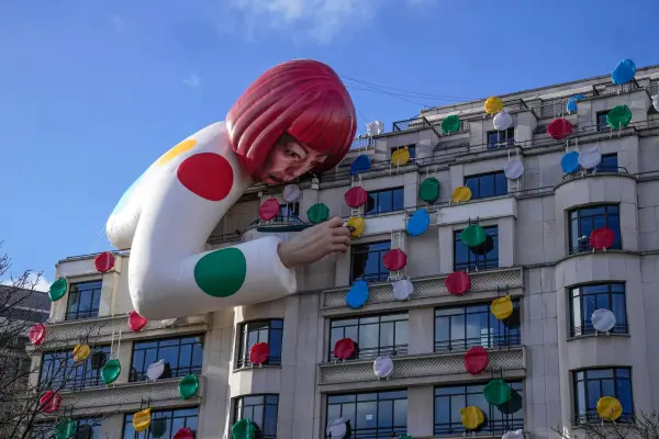 FILE - The installation of Japanese artist Yayoi Kusama, peering over the Louis Vuitton flagship store is pictured at the Champs Elysees avenue in Paris, Sunday, Jan. 15, 2023. (AP Photo/Michel Euler, File)