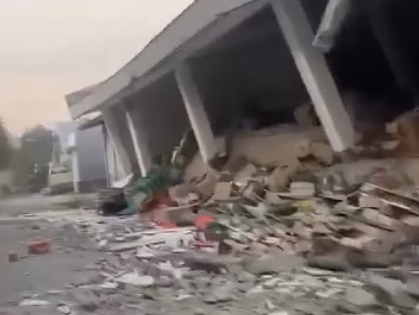 Обломки засипали дорогу перед похилою будівлею.