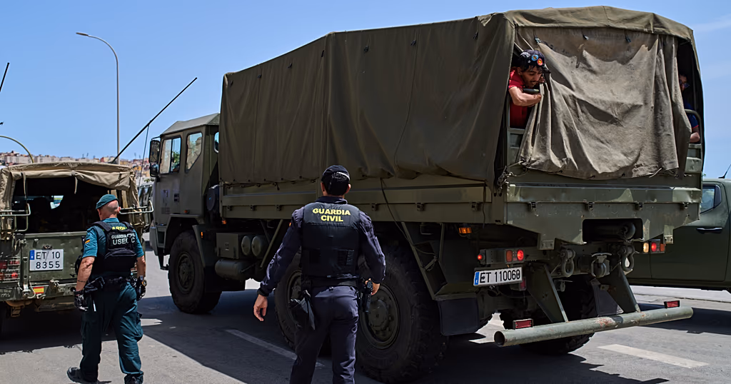 Мігранти біля паркану, що відділяє Сеуту від Марокко