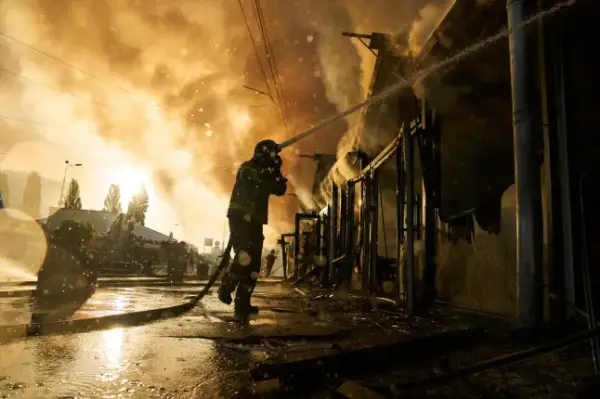 Firefighters try to put out a fire at a city book market following a Russian missile attack in Kyiv, Ukraine, early Sunday, Aug. 16, 2026. (AP Photo/Francisco Seco)
