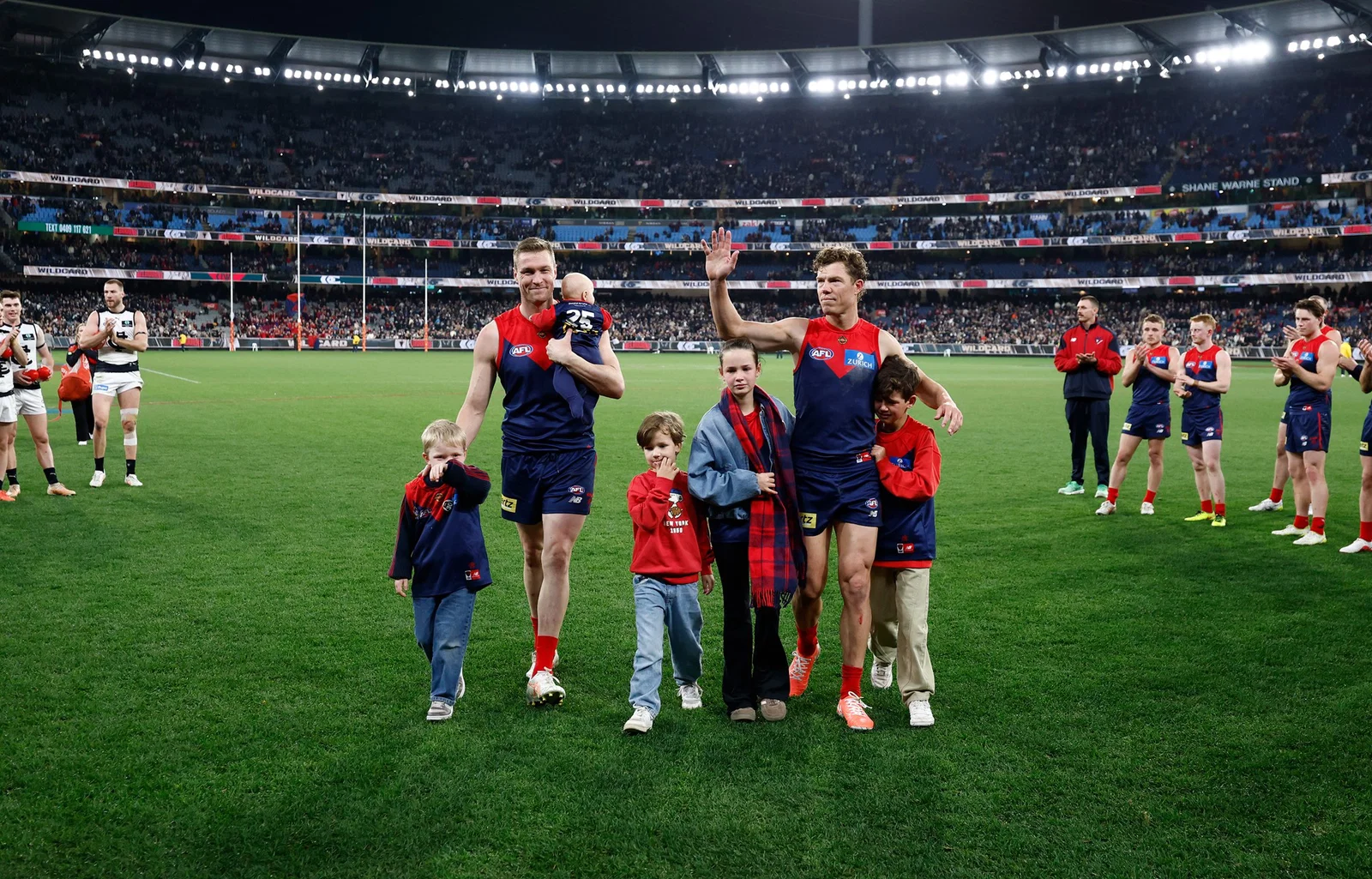 Tom McDonald (left) and Jake Melksham of the Demons (right) are seen with their families after playing their final match during the 2026 AFL First Wildcard Final between the Melbourne Demons and the Carlton Blues at the Melbourne Cricket Ground on August 29, 2026 in Melbourne, Australia.