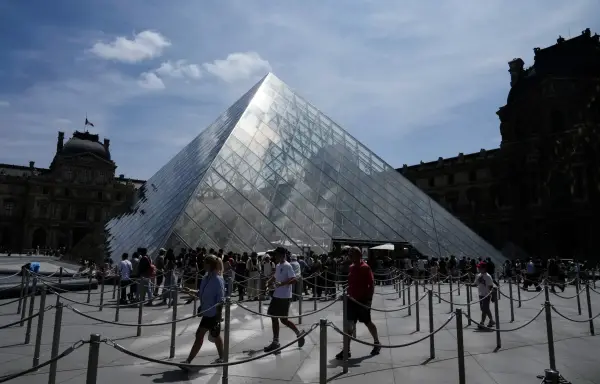 People lined at the pyramid during the reopening to the public of the Apollo Gallery, at the Louvre museum in Paris, Wednesday, July 22, 2026. (AP Photo/Michel Euler)