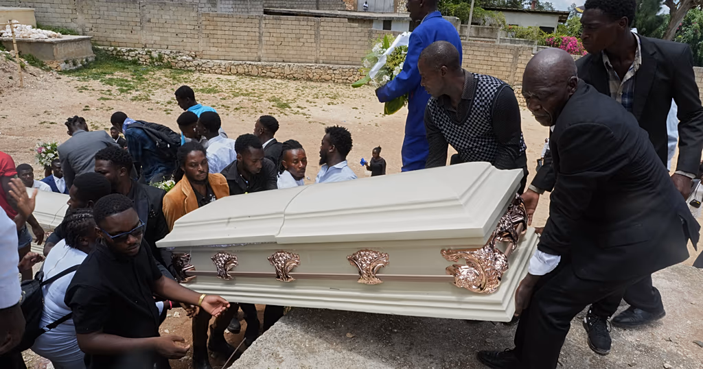 Relatives lift the coffin of a gang attack victim for burial at the cemetery in the Kenscoff neighborhood of Port-au-Prince, Haiti, Sunday, Aug. 30, 2026.