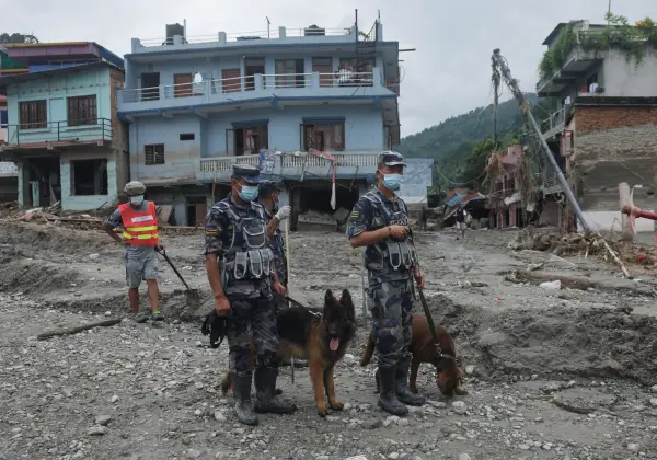 Armed Police Force officials stand with sniffer dogs at the disaster site of flash floods and mudslides, in Devighat, Nuwakot district, Nepal, August 29, 2026. REUTERS/Francis Mascarenhas