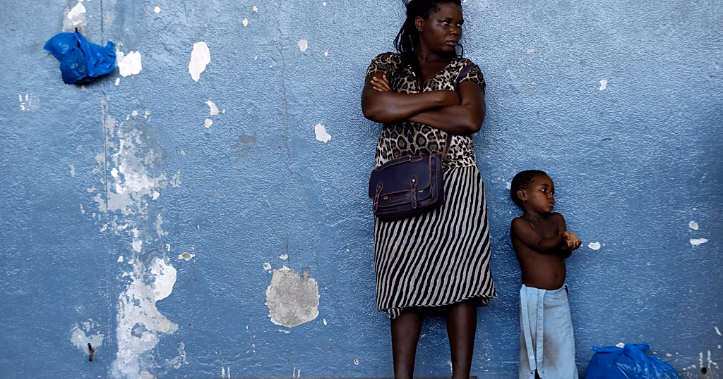 A woman and her child send against the wall at a displacement centre in Beira, Mozambique, Friday, March 22, 2019.