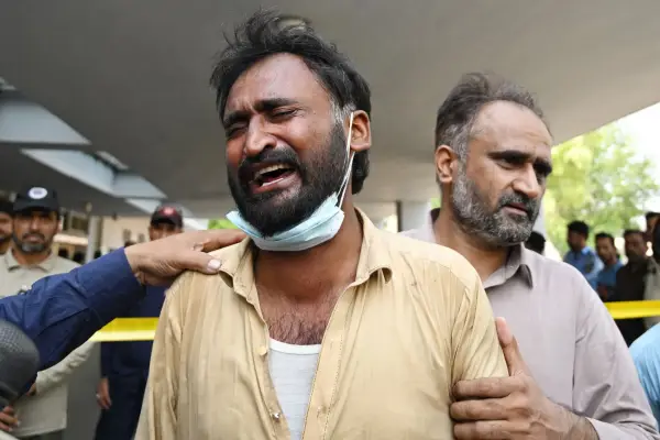 A father reacts after the death of his child following a fire incident outside the Mother and Child Health (MCH) ward at the Pakistan Institute of Medical Sciences (PIMS) Hospital in Islamabad on August 26, 2026. A fire at a hospital in the Pakistani capital Islamabad on August 26 morning killed 14 children, a local authority said. (Photo by Aamir QURESHI / AFP via Getty Images)