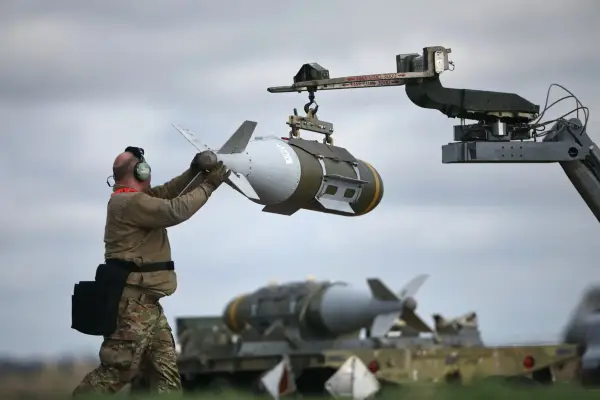 TOPSHOT - US Military personnel take away Joint Direct Attack Munitions (JDAMs), removed from a US Air Force B-1 Lancer bomber at RAF Fairford in south-west England on March 15, 2026. Fairford is one of two bases, along with the Diego Garcia facility in the Indian Ocean, that the UK has given the US permission to use for