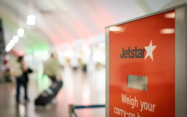 Ваги Jetstar для зважування багажу біля виходу на посадку.