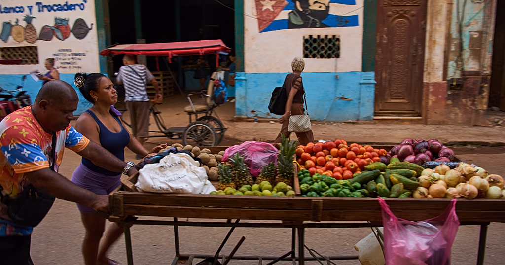 Street vendors push their cart of vegetables past a mural of Fidel Castro in Havana, Cuba, 12 August 2026.