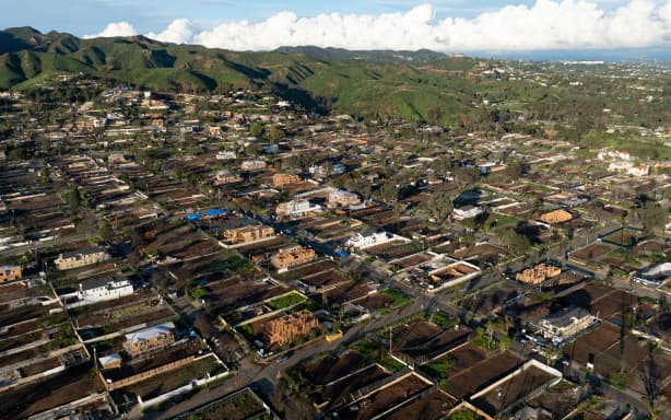 An aerial view shows empty lots and new homes under construction in Pacific Palisades, California on January 5, 2026. Altadena was hardest hit by the fires that ravaged parts of the sprawling US metropolis in January 2025. Thousands of homes were destroyed and 19 people died in the town -- compared to 12 killed in the upscale Pacific Palisades neighborhood. (Photo by JOSH EDELSON / AFP)