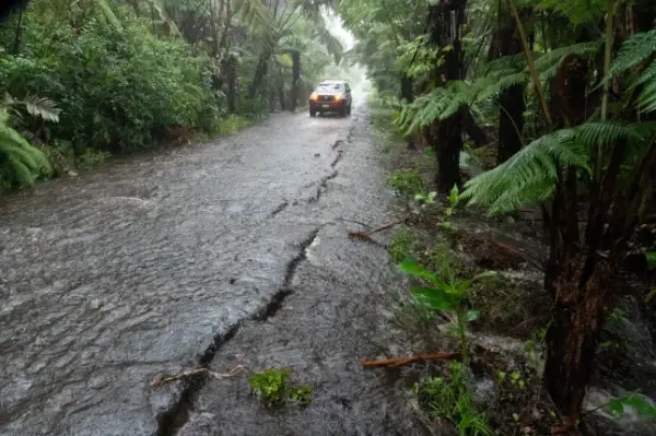 A rural road floods in Volcano Village at 4000' elevation on Hawaii Island, on August 15, 2026. Hurricane Lala on Saturday lashed Hawaii's Big Island with heavy rain and strong winds, as forecasters warned of potentially dangerous flooding across the US Pacific island state. Lala strengthened into a Category 1 hurricane at around 9:00 am local time (1900 GMT), generating winds of up to 75 miles per hour (120 kilometers per hour). (Photo by Jill K. Briggs / AFP via Getty Images)