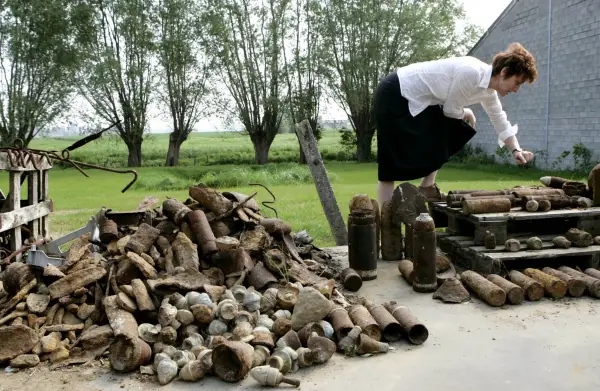 FILE - Charlotte Cardoen-Descamps points out different types of World War I shells that were found on her farm in Poelkapelle, Belgium, May 4, 2007, in what is known as the